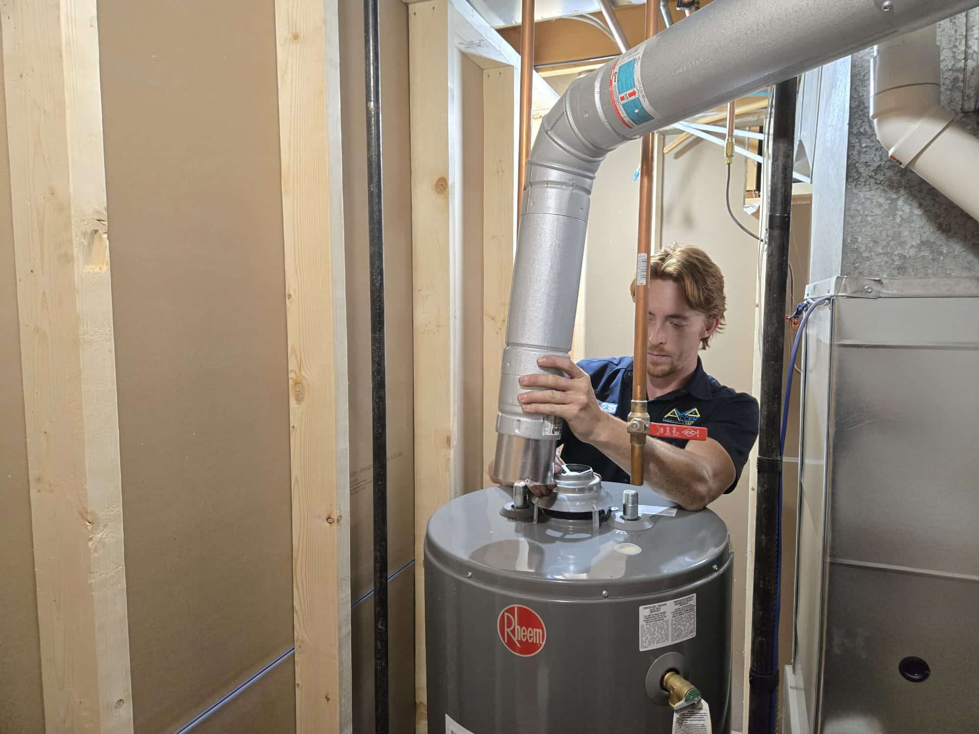 An Accent Plumbing and Heating technician fitting the vent to a new Rheem hot water tank