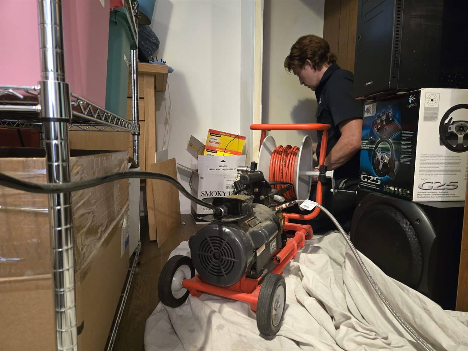An Accent Plumbing and Heating technician running a hydro jetter in a Calgary basement