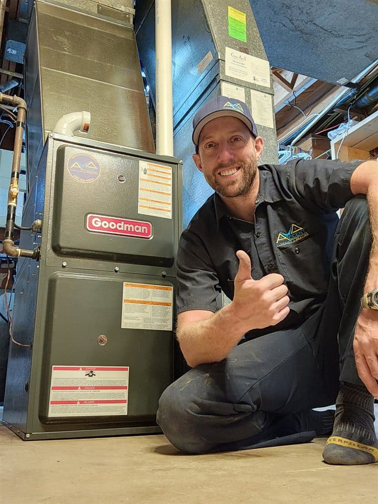 Ben from Accent Plumbing and Heating giving a thumbs up beside a furnace he has installed