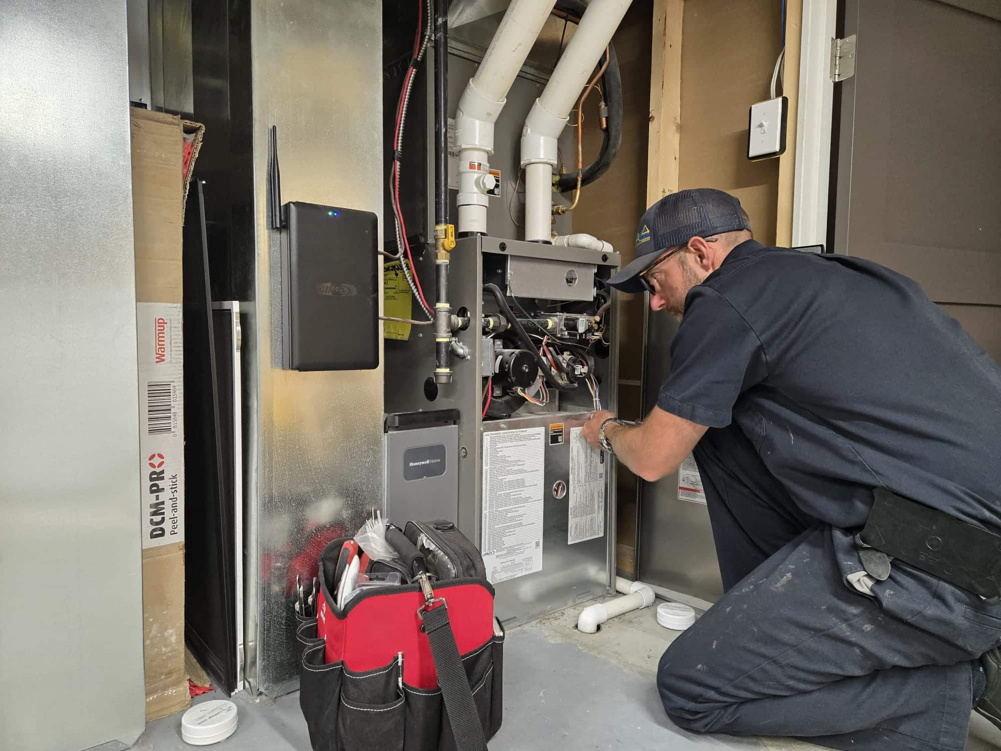 Ben from Accent Plumbing and Heating servicing an open furnace in a Calgary basement