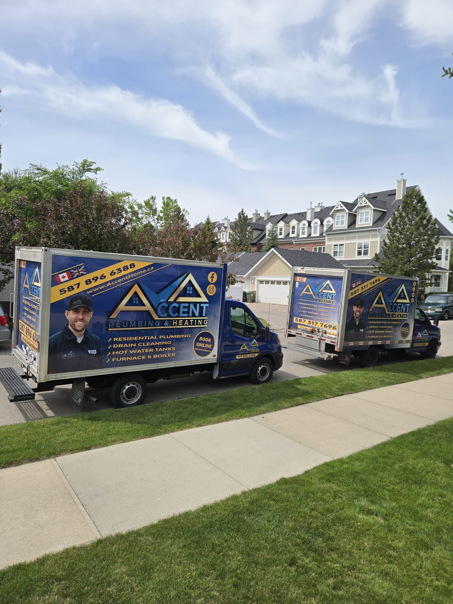 Two Accent Plumbing and Heating vans parked on a Calgary street
