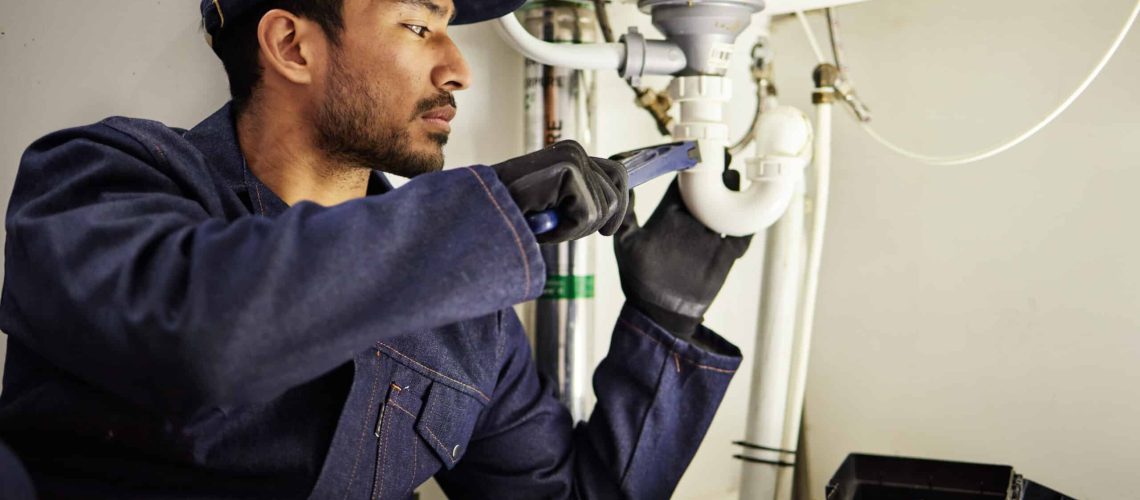 Plumbing, pipes and maintenance with man in kitchen for repair, industrial and inspection. Handyman.